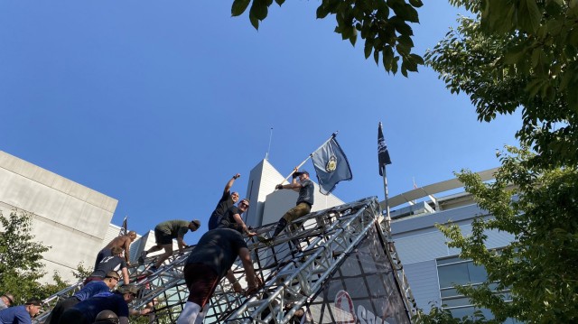 Soldiers of the Army Cyber Protection Brigade (CPB) scale an obstacle carrying the brigade's colors during a Spartan 5K race at Nationals Park in Washington, D.C., Sept. 11, 2021. The participants from the CPB's headquarters and Company C, 2nd...