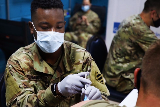 Spc. Dorien Lewis, a combat medic with Division Sustainment Troops Battalion MEDOPS, 3rd Division Sustainment Brigade, administers the Moderna COVID-19 vaccine to a U.S. Army Soldier at Camp Arifjan, Kuwait, Aug. 17. Medics across Camp Arifjan, held a COVID-19 vaccine drive for personnel that are not fully vaccinated. (U.S. Army photo Sgt. Marquis Hopkins)