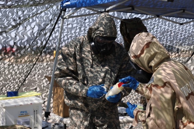 Pfc. Jason Miller, Chemical, Biological, Radiological and Nuclear (CBRN) Specialist assigned to the 46th Chemical Company (Technical Escort) receives a packaged sample from his teammate Pfc. Samantha Gonzalez, Sept 12, 2021, during a joint training exercise held at the Mission Training Complex on Fort Bliss, Texas. The exercise was held to validate 22nd Chemical Battalion for an upcoming mission. (U.S. Army photo by Marshall R. Mason)