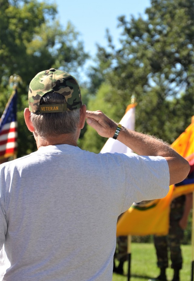 A veteran salutes the American flag during the posting of the colors at the Americal Division Memorial Dedication at Rock Island National Cemetery in Illinois. Photo by: Staci-Jill Burnley, ASC Public Affairs
