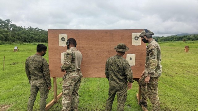 During Salaknib ’21, U.S. Army Soldiers, Staff Sgt. Matthew Robinson and Sgt. Joseph Conn from Maneuver Advisor Team 5212, Force Package 21-2, discuss sight adjustments during a small arms range with the Philippine Army’s 1st Brigade Combat Team, July 12, 2021 at Fort Magsaysay, Philippines.