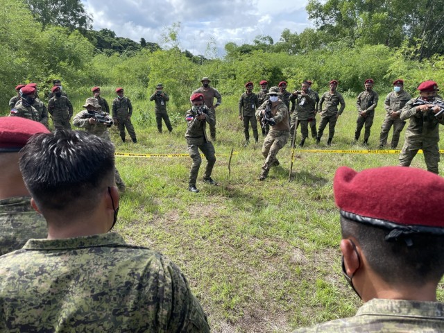 Staff Sgt. Nicholas Shrader and Sgt. 1st Class Robby Batongtong, Maneuver Advisor Team 5212, Force Package 21-2, partner with a fire team from the Philippine Army’s 1st Brigade Combat Team, July 12, 2021 to demonstrate how to enter and clear a building at Fort Magsaysay, Philippines during Salaknib ’21.