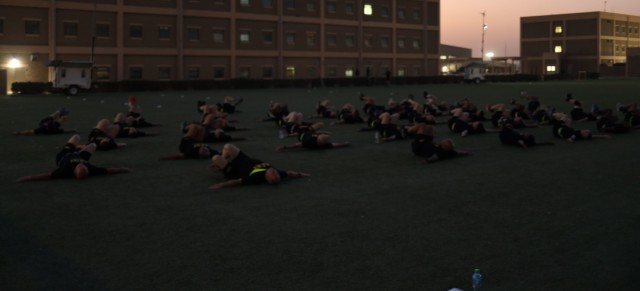 Sergeants majors from across Camp Arifjan, Kuwait, execute the bent-leg-body-twist, one of the Physical Readiness Training, or PRT, conditioning drills done before they began a Sept. 12, 2021, physical fitness round-robin based on the Army Combat Fitness Test. The 37 sergeants major joined Command Sgt. Maj. Brian A. Hester, U.S. Army Central Command's senior enlisted advisor, at the event that began at 0500 to avoid the Kuwaiti sun.