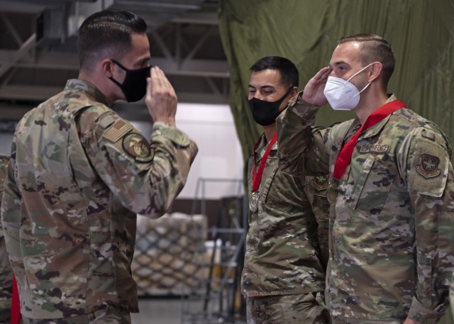 U.S. Air Force Maj. Wesley Ekwall, 62nd Aerial Port Squadron commander, presents a medal to Senior Airman Connor Dickson, air terminal operations center information controller with the 62nd APS, at Joint Base Lewis-McChord, Washington, Sept. 15,...