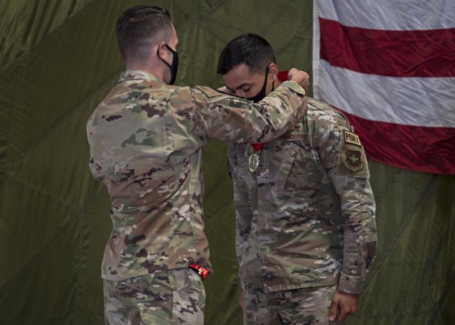 U.S. Air Force Maj. Wesley Ekwall, 62nd Aerial Port Squadron commander, presents a medal to Tech. Sgt. Ronald West, NCO in charge of fleet operations with the 62nd APS, at Joint Base Lewis-McChord, Washington, Sept. 15, 2021. West, the Eagle Port team lead, and his team competed at the 2021 Pacific Air Forces (PACAF) Port Dawg Rodeo in August and brought home two first place event awards and the award for Top Port Dawg Team. (U.S. Air Force photo by Senior Airman Zoe Thacker)