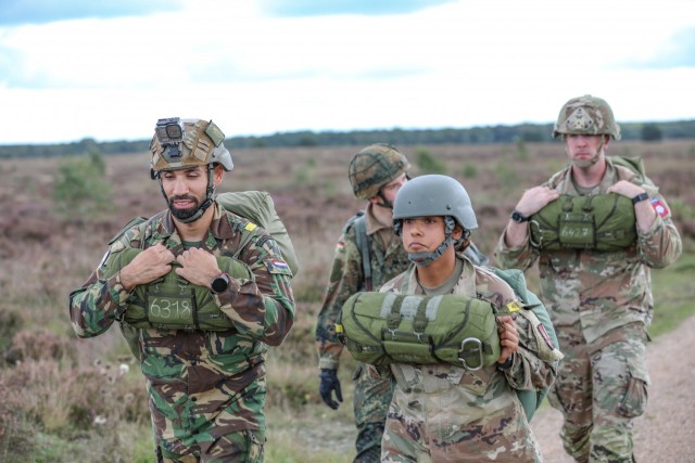 Spc. Sonia Morales (right/front), 294th Quartermaster Company, 372nd Combat Sustainment Support Battalion walks off the Houtdorpveld drop zone with other NATO military partners during Falcon Leap, Sept. 16, 2021, in the Netherlands. The exercise...