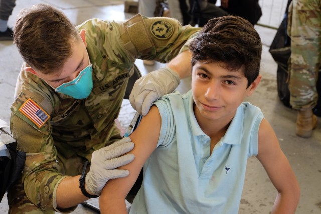 Pvt. Hayden McClure, an Army medic assigned to 1st Squadron, 2nd Cavalry Regiment, administers an MMR vaccine to an Afghan evacuee at Rhine Ordnance Barracks, Germany, Sept. 18. A diverse team of Army medical professionals vaccinated nearly 5,500...