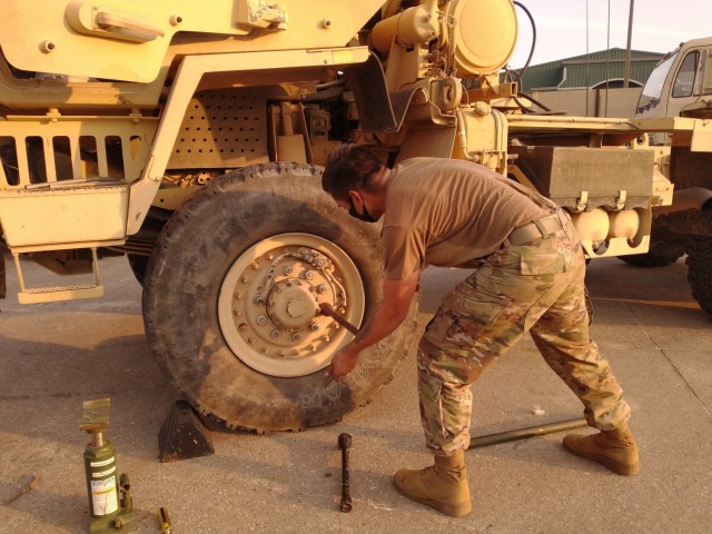 U.S. Army Spc. Juan Lozano changes a front tire on an up-armored Medium Tactical Vehicle with the 418th Transportation Company, 13th Expeditionary Support Company, 61st Quartermaster Battalion, Baton Rouge, LA. (Released/U.S. Marine Corps photo by 1st Lt. Aaron Ladd)
