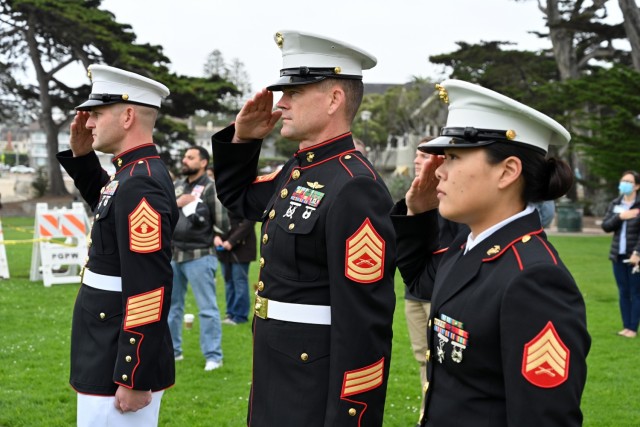 From left, Master Gunnery Sgt. Jeffrey T. Rooke, senior enlisted leader, Marine Corps Detachment, Presidio of Monterey, Gunnery Sgt. Matthew Archbold, and Sgt. Joan Lee salute for the national anthem at Lovers Point Park, Pacific Grove, Calif., Sept. 17, during the “Afghanistan Servicemembers Memorial” for the 13 service members killed in action at the Kabul Airport on Aug. 26.