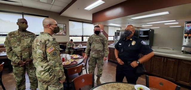 From left, Maj. Quenten Vereen, Maj. Jason Pavlik, and Chaplain (Capt.) Thomas Pope of the 97th Military Police Battalion speak with Maj. Oscar Ruiz, Assistance Chief of the Kansas State University Police Department at the inaugural law...