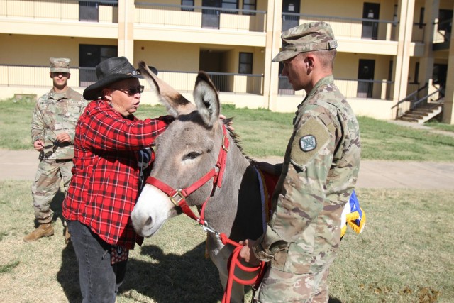 Diana Burns gives Spc. Carl Romer a few tips on caring for Big Deuce VIII. Burns and her husband, Todd, own the DT Ranch in Marlow, Oklahoma, and arranged a swap of Big Deuce VII for Big Deuce VIII.