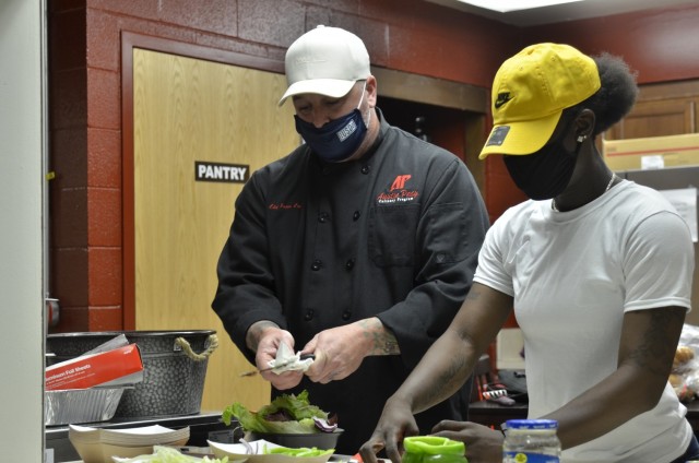 Private First Class Tequila Towns learns cutting techniques from retired Master Sgt. Jason Coy, adjunct professor of culinary arts at Austin Peay State University, Sept. 9 during the inaugural “Cookin’ in the Bs” class hosted at USO Fort Campbell.