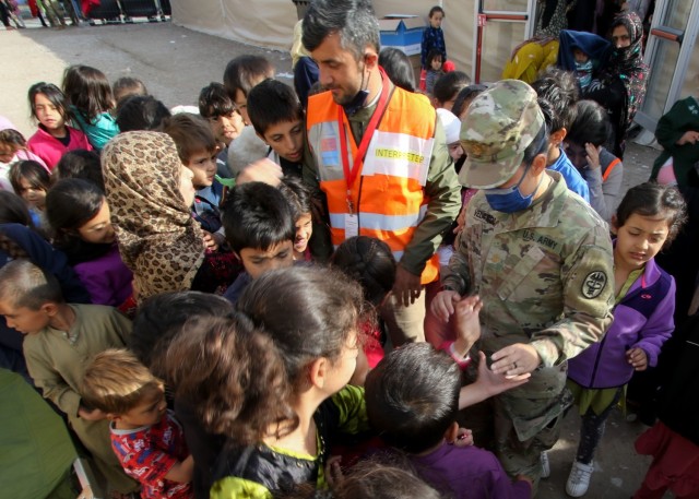 U.S. Army Maj. Regina Velasco, an obstetrics nurse assigned to Bassett Army Community Hospital, Fort Wainwright, Alaska, and native of O'ahu, Hawaii, provides treats to children at currently housed at Rhine Ordnance Barracks, in Kaiserslautern, Germany, Sept. 22. Velasco is one of more than 50 Army Medicine personnel from across the United States who are augmenting Landstuhl Regional Medical Center in support of ongoing medical operations as part of Operation Allies Welcome.