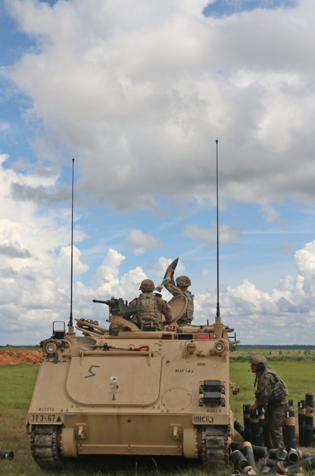 A Soldier assigned to the mortar section 3rd Battalion, 67th Armored Regiment, 2nd Armored Brigade Combat Team, 3rd Infantry Division, prepares to fire a 120mm round while his squad leader confirms direction of fire at OP4 on Fort Stewart,...