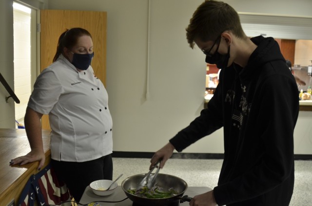 Sergeant Dani Weinberger, 5th Special Forces Group (Airborne), cooks up a steak sandwich with guidance from MaLissa Harris, center operations supervisor, USO Fort Campbell, Sept. 9 during the facility’s inaugural “Cookin’ in the Bs” class.
