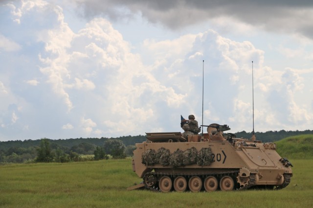 A Soldier assigned to the mortar section of 3rd Battalion, 67th Armored Regiment, 2nd Armored Brigade Combat Team, 3rd Infantry Division, prepares to fire a 120mm round while his squad leader confirms direction of fire at OP4 on Fort Stewart,...
