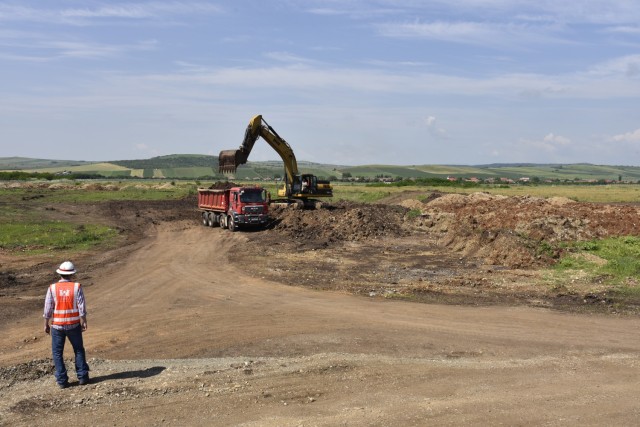 U.S. Army Corps of Engineers, Europe District Project Engineer Kevin Gray keeps an eye on contractors loading soil as part of ongoing construction activities at Campia Turzii Air Base, Romania, during a site visit June 22, 2021. The U.S. Army...