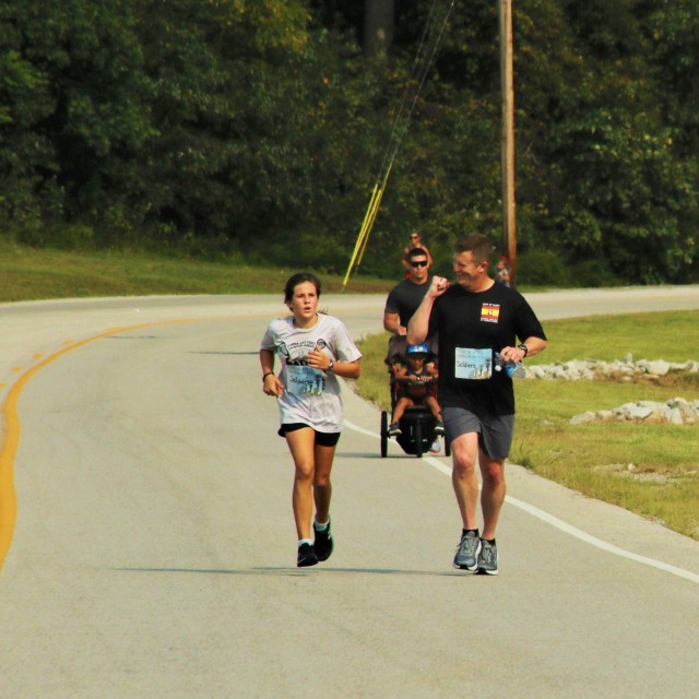 Colonel Patrick Moffett, commander of 101st Division Artillery, 101st Airborne Division (Air Assault), finishes the Hero Run with his daughter, Emma Moffett, Sept. 11 at the Shaw Physical Fitness Center. Some runners dedicated their runs to those who perished on Sept. 11, 2001, or to the Soldiers who died fighting the war that ensued afterward.