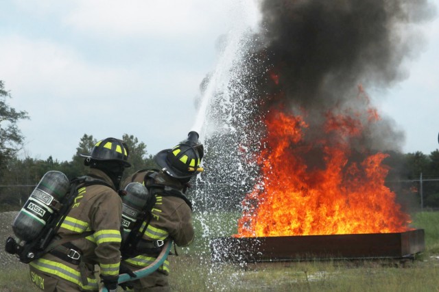 Firefighters Wilson Smith and Thomas Farst, Clarksville Fire Rescue, combat an outdoor fire Sept. 16 during Fire Fighter I and Fire Fighter II live fire practical evaluations at Fort Campbell Fire and Emergency Services’ training facility.
