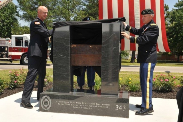Kevin Baylor, then-chief, Fort Campbell Fire and Emergency Services, and Col. Perry C. Clark, then-Fort Campbell garrison commander, unveil the FCFES 9/11 monument during a dedication ceremony hosted May 24, 2012, outside Fire Station 1. The display includes an I-beam from the World Trade Center’s South Tower, and the 343 inscribed on the granite represents the number of firefighters who died Sept. 11, 2001.
