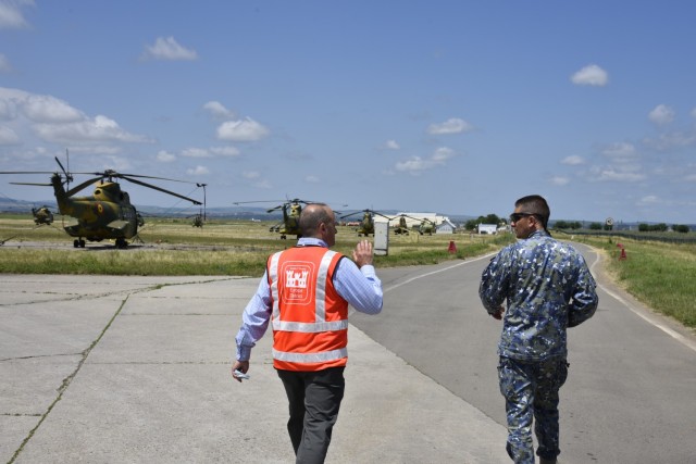 U.S. Army Corps of Engineers, Europe District Southern Europe Area Engineer Bryce Jones discusses plans for future construction projects at Campia Turzii Air Base, Romania, with Romania Air Force Chief of the Host Nation Support Office Maj. Cosmin...