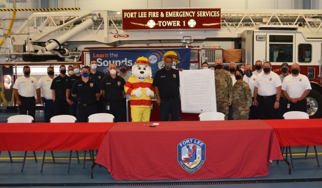 Members of the Fort Lee Fire Department pose with Garrison Commander Col. Karin L. Watson; Sgt. Maj. Alain Nadeau, Directorate of Emergency Services SGM; and Sparky the Fire Dog during the conclusion of the 2021 Fire Prevention Week Proclamation signing ceremony Monday in Fort Lee Fire Station 2. (U.S. Army photo by Patrick Buffett)