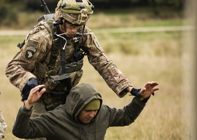 U.S. Army Sgt. Benjamin Koger, Alpha Company, 1st Battalion, 16th Infantry Regiment “Iron Rangers,” 1st Armored Brigade Combat Team, 1st Infantry Division, detains a prisoner of war during a multinational situational training exercise in...