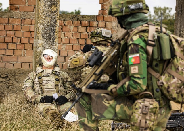 A U.S. Army Soldier assigned to Alpha Company, 1st Battalion, 16th Infantry Regiment “Iron Rangers,” 1st Armored Brigade Combat Team, 1st Infantry Division, and a Portuguese Soldier provide tactical medical care for a simulated casualty in...
