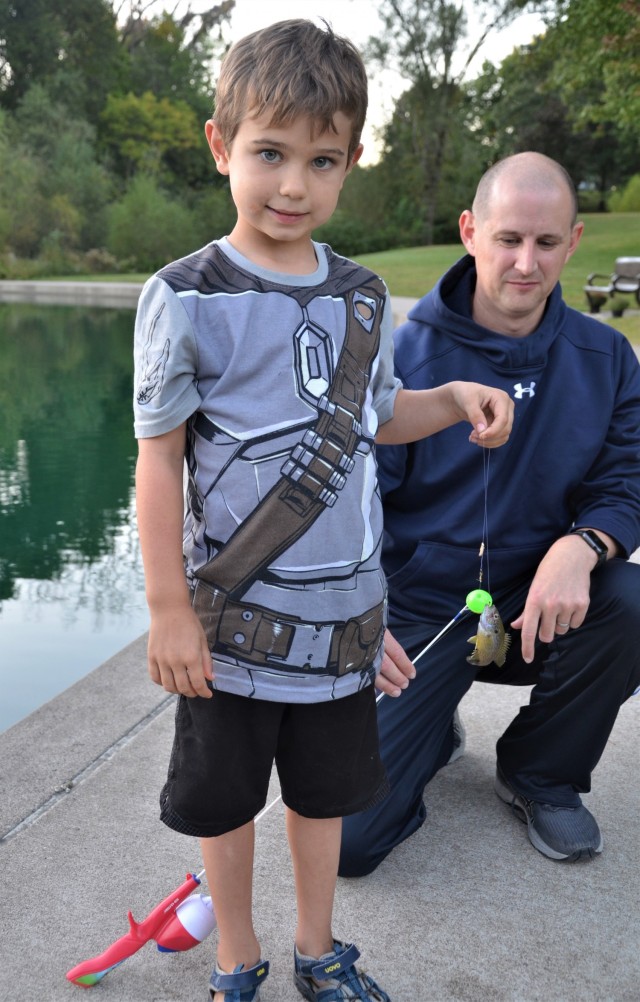 Philip Heelan admires his son, Isaac’s, first catch at the Fatherhood Fishing Derby at Rock Island Arsenal, Illinois, Sept. 23.