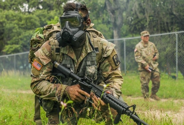 Spc. Justin Earnhart, assigned to the 470th Military Intelligence Brigade, pulls security while wearing a joint service general purpose mask during an exercise in the Army Futures Command&#39;s Best Warrior Competition on Fort Sam Houston, Texas,...