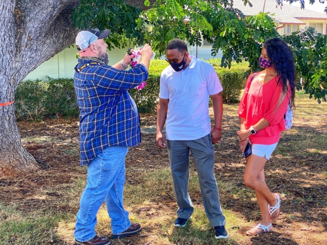 Clint German presents Marcus Harris with a lei at the 402nd Ary Field Support Brigade's recent Hail and Farewell. Hail and Farewell events are held once a quarter to welcome the brigade's newest members and recognize team members leaving the...