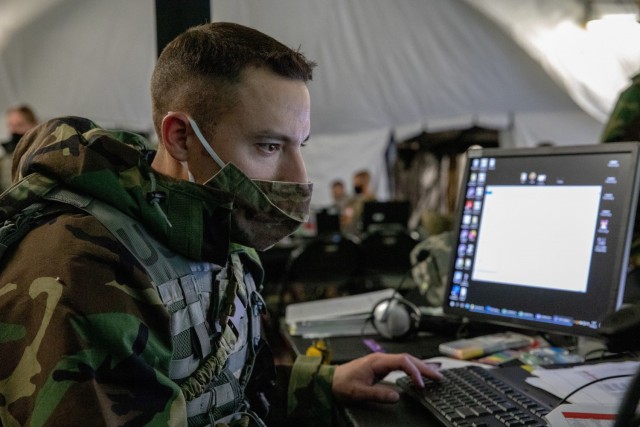 Sgt. Travis Tasler, a battle noncommissioned officer with the 347th Human Resources Company of the Minnesota National Guard, monitors a computer during an exercise on Aug. 14, 2021. In addition to making systems more resilient to hardware and software failures, application security containers will deny malicious actors from gaining access to the computer networks through backdoor channels.