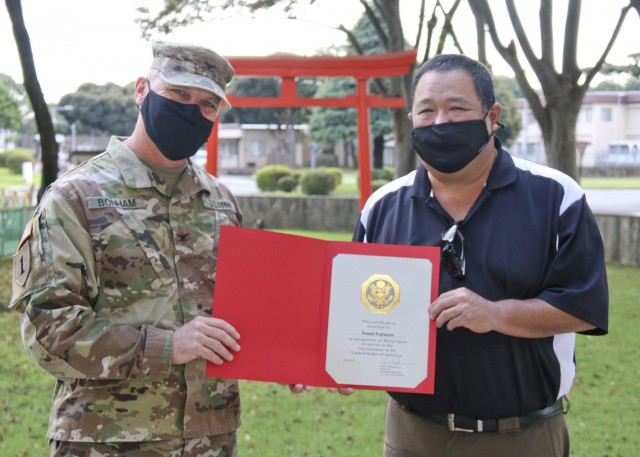 Daniel Fujimoto, Japan Engineer District safety chief, receives his 30 years of service recognition from Col. Gary Bonham, Japan Engineer District commander, during a ceremony at Camp Zama, Japan. Fujimoto is one year into his second tour with the Corps in Japan.