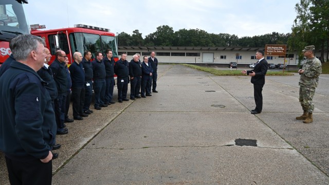 Installation Management Command-Europe Director Tommy Mize addresses firefighters from U.S. Army Garrison Rheinland-Pfalz's Sembach Fire Station Tuesday, Oct. 5, 2021. Mize toured the facility with IMCOM-E Command Sgt. Major Christopher D. Truchon and awarded IMCOM-E coins to a pair of fire inspectors assigned to the garrison working Operation Allies Welcome safety and fire issues.