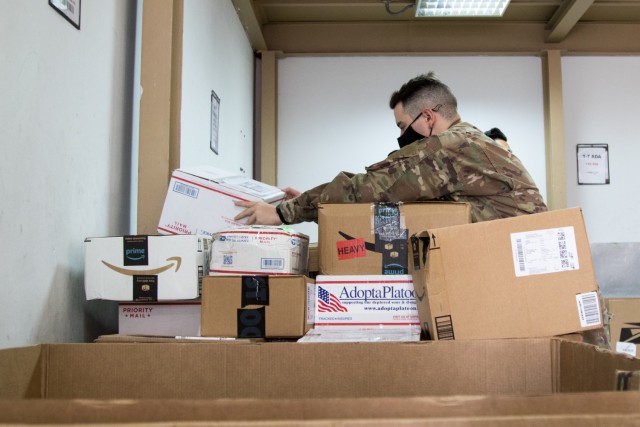 Cpl. Brett D. Ellis, a human resources specialist assigned to the Fort Bragg, North Carolina, based Headquarters and Headquarters Company, 3rd Expeditionary Sustainment Command, stacks parcels bound for Soldiers at his unit at the post office on Camp Arifjan, Kuwait, on Oct. 2, 2021. Ellis, a native of Fort Worth, Texas, is one of many Soldiers who deployed to Kuwait in August to staff the 1st Theater Sustainment Command Operational Command Post. (U.S. Army photo by Sgt. 1st Class Mary S. Katzenberger)