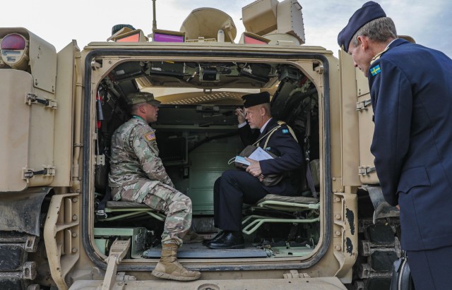 U.S. Army Staff Sgt. David Wardlow (left), an infantryman assigned to 1st Battalion, 16th Infantry Regiment, 1st Armored Brigade Combat Team, 1st Infantry Division, explains the capabilities of an M2A3 Infantry Fighting Vehicle (Bradley) to...