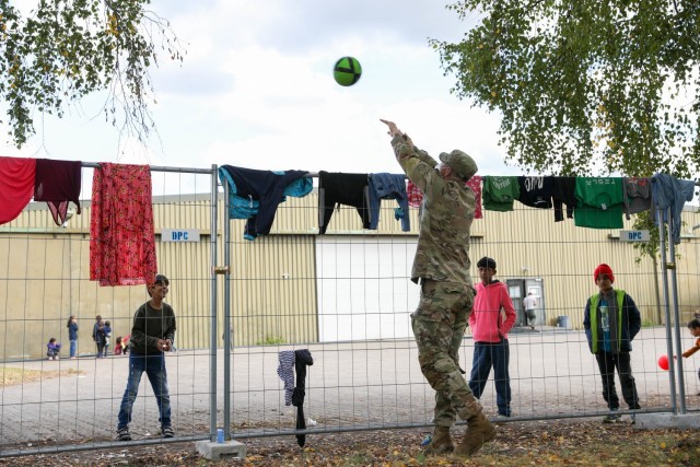 U.S. Army Sgt. 1st Class Aaron Shaw, Kronos Troop with 2nd Calvary Regiment plays catch with an Afghan child Sept. 30, 2021 at the Rhine Ordnance Barracks in Kaiserslautern, Germany. Sgt. Shaw is part of the joint security force during Operation...