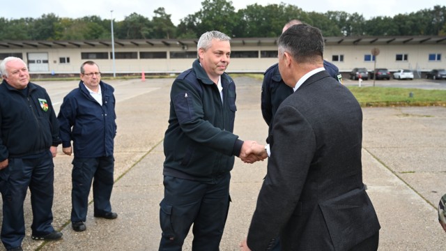 Installation Management Command-Europe Director Tommy Mize presents a newly created IMCOM-E coin to U.S. Army Garrison Rheinland-Pfalz Fire Inspector Daniel Scherer at the Sembach Fire Station Tuesday, Oct. 5, 2021. Mize recognized Scherer and...