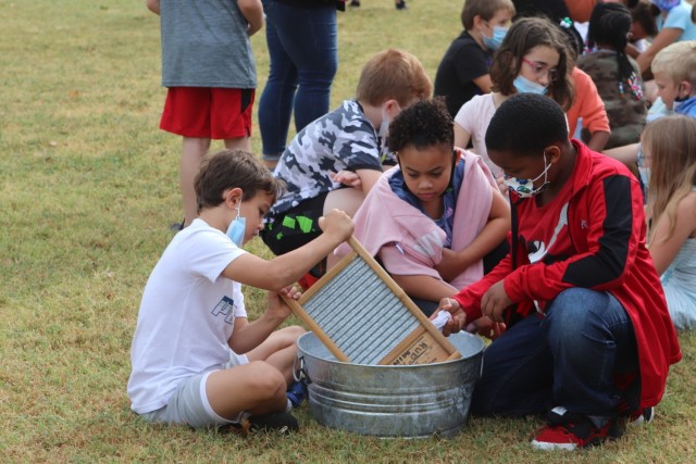 Gunner Platner, Taliah Gibbs, and Donari Frances, third graders from Almor West Elementary School in Lawton try washing clothes the old-fashioned way Oct. 1, 2021, on Fort Sill’s Old Post Quadrangle. The 19th century laundry demonstration was part of Frontier Army Days that acquainted schoolchildren with life on Fort Sill when it was founded in 1869.