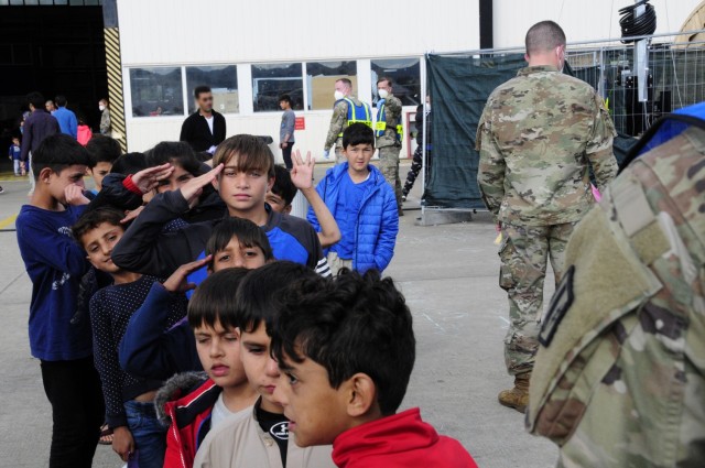 A young Afghan boy renders a proper military salute to the Soldiers assigned to 1st Battalion, 77th Field Artillery Regiment, while waiting in line to enter the temporary school house at Ramstein Air Base, Germany on Sept. 30, 2021. Approximately...