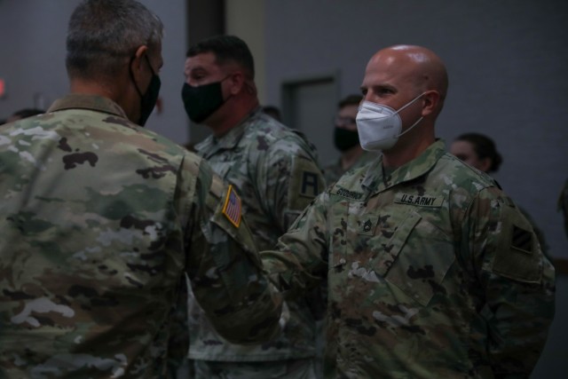 Sgt. 1st Class Gregory Goodrich, a plans and operations noncommissioned officer assigned to Headquarters and Headquarters Battalion, 3rd Infantry Division, receives a challenge coin from Maj. Gen. Charles D. Costanza, commanding general of the...