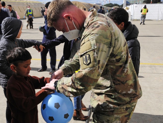 Sgt. First Class Brooks Robinson, a platoon sergeant assigned to 1st Battalion, 77th Field Artillery Regiment, plays ball with Afghan children in the courtyard at Ramstein Air Base, Germany while checking up on his Soldiers that are conducting...