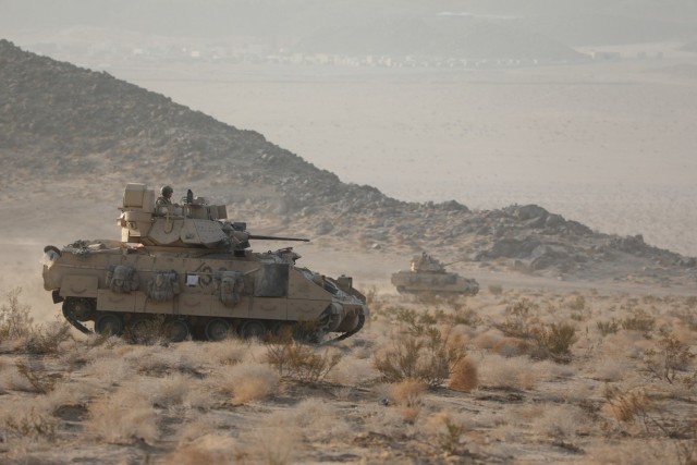 Two U.S. Army Bradley Fighting Vehicles form the 4th Battalion, 70th Armored Regiment, 1st Armored Brigade Combat Team, 1st Armored Division, maneuver across the National Training Center during Decisive Action Rotation 21-10 on Fort Irwin, California, Sept. 20. Decisive action rotations at the National Training Center ensure Brigade Combat Teams remain versatile, responsive and consistently available for current and future contingencies. U.S. Army photo by Cpl. Gosselin Ryan, Operations Group, National Training Center.