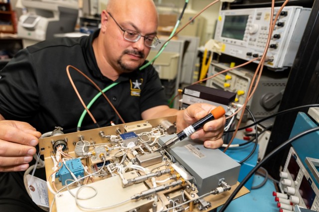 Electronics Mechanic James Eiden uses a torque wrench to install hard lines on a AN/FPS-117 radar system receiver.