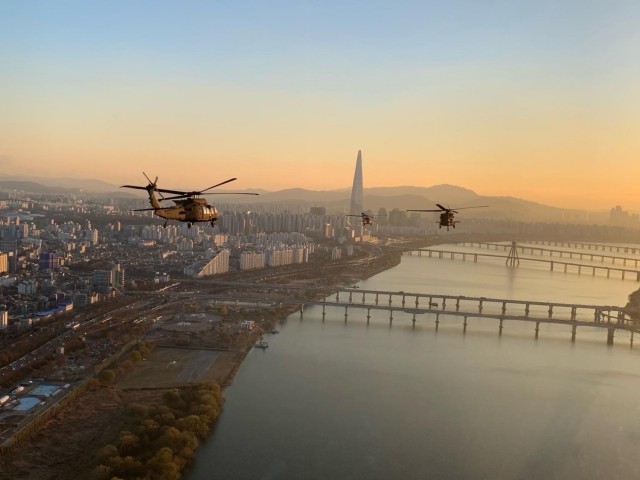 UH-60 Black Hawks fly over Seoul, South Korea, with the Lotte World Tower in the background. The tower is the tallest building in South Korea. 