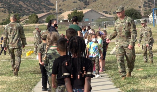 (left) Soldiers from the 40th Expeditionary Signal Battalion put Colonel Johnston Elementary School students through tasks to give them a better understanding of Army life and help build community.
