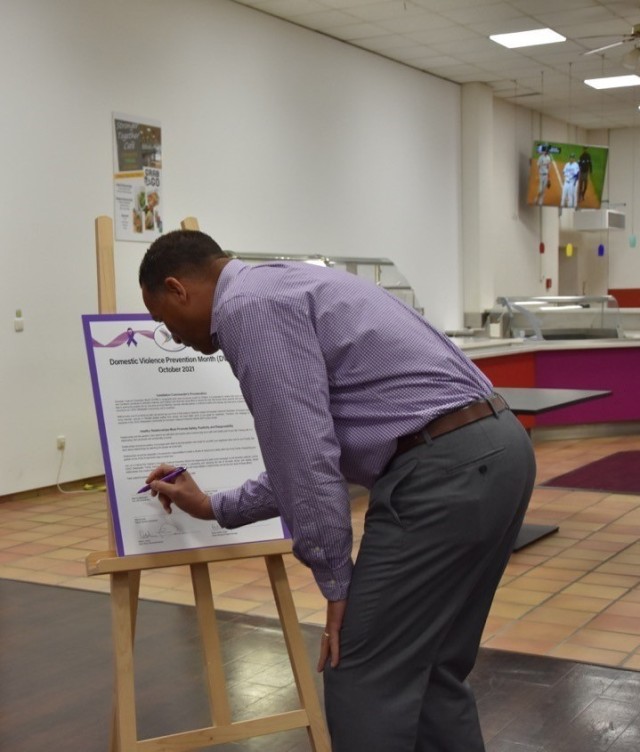 The U. S. Army Garrison Wiesbaden Commander, Col. Mario Washington, signs a proclamation on Domestic Violence Awareness Oct. 7 at the Garrison Dining Facility.