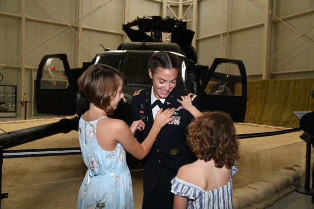 U.S. Army Warrant Officer 1 Jessica L. Burns enlists the help of her daughters to pin her Army aviation wings as she graduates flight school at the U.S. Army Aviation Museum at Fort Rucker, Alabama, October 7, 2021. Previously as a noncommissioned officer, Burns was one of the Army's first female drill sergeants at Sand Hill, Fort Benning, Georgia. (U.S. Army photo by Kelly Morris)