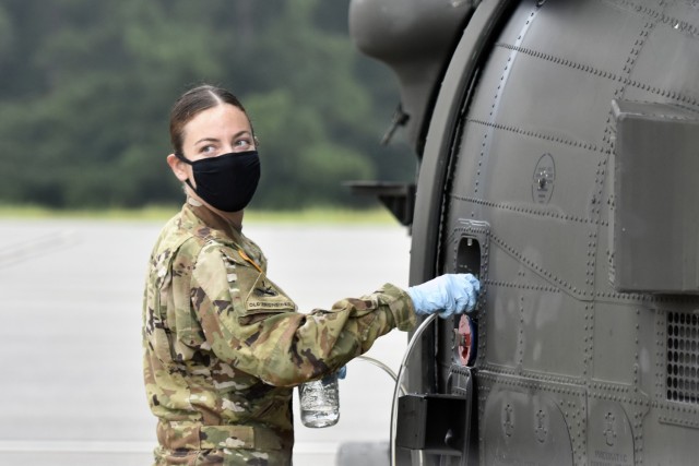 Warrant Officer Jessica Burns pulls a fuel sample while preflighting a UH-60M Black Hawk helicopter at Fort Rucker, Alabama, Aug. 3, 2021. Burns has completed Initial Entry Rotary Wing flight training, and is a student pilot in the Black Hawk track. (U.S. Army photo by Lt. Col. Andy Thaggard)