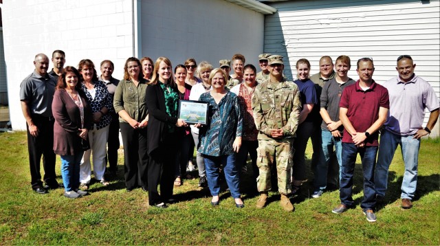 Members of the Fort McCoy Resource Management Office (RMO) and the Fort McCoy Garrison command team (Garrison Commander Col. Michael Poss, Deputy Garrison Commander Lt. Col. Chad Maynard, and Command Sgt. Maj. Raquel DiDomenico) stop for a photo Sept. 30, 2021, as RMO team members are recognized for excellence with a Garrison Command Team Certificate of Excellence at Fort McCoy, Wis. The RMO team recently completed the busy end-of-fiscal-year budget cycle and were holding an organizational day when they were recognized for their work during fiscal year 2021. Bonnie Hilt and Maureen Richardson of RMO are shown holding the certificate. (U.S. Army Photo by Scott T. Sturkol, Public Affairs Office, Fort McCoy, Wis.)
